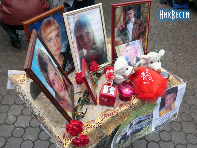 Митингующие разместили на столике фото погибших детей, свечки и их игрушки